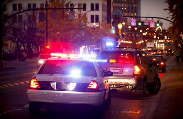 A police officer pulls over a driver for a traffic violation in a downtown city